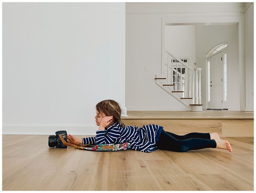 Child lying on the floor taking a picture with a Nikon camera smart phone photography tips