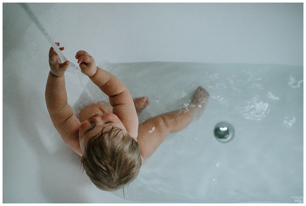 a mother bathing with her baby is one of Three Reasons to hire a Photographer